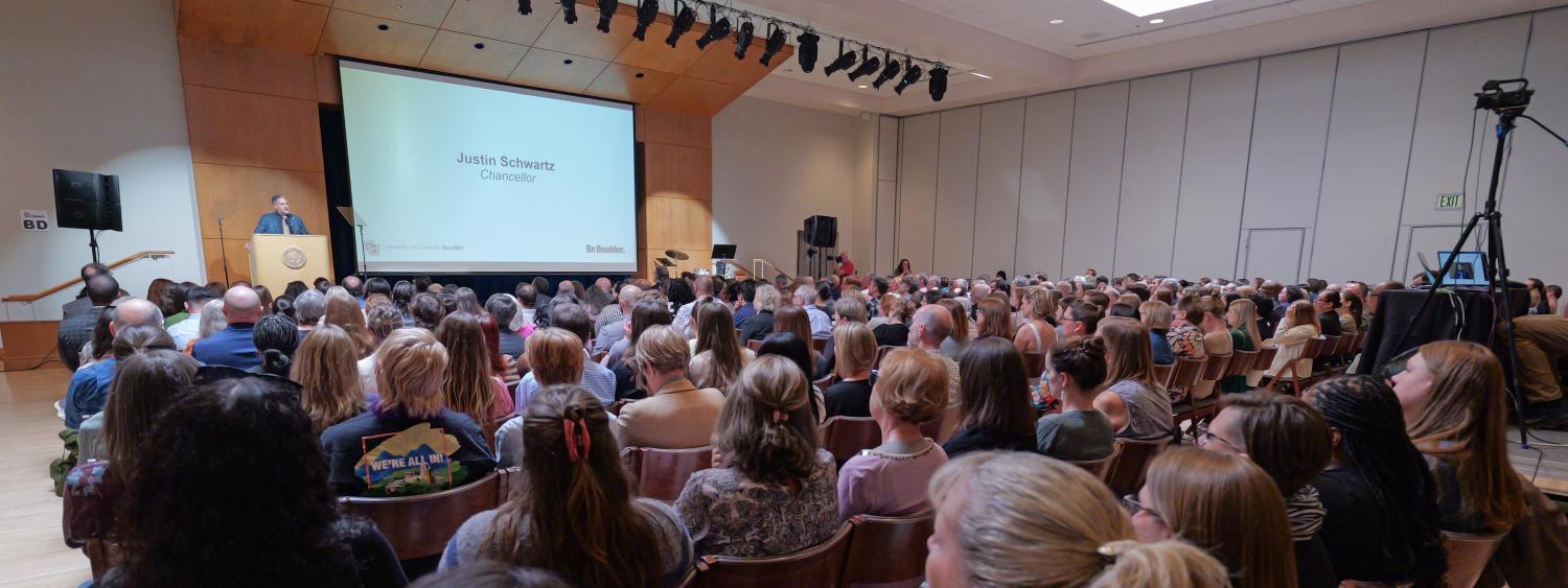 A room full of people listening to the State of the Campus address.