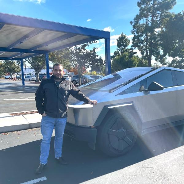 Ben Mousseau standing next to a Tesla.