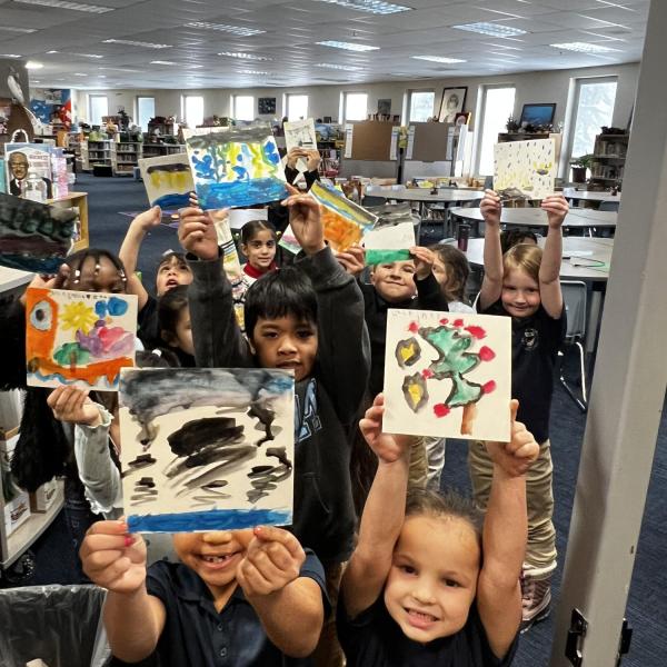 Children holding up their artwork.