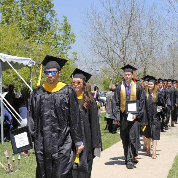 Graduates walk toward stage.