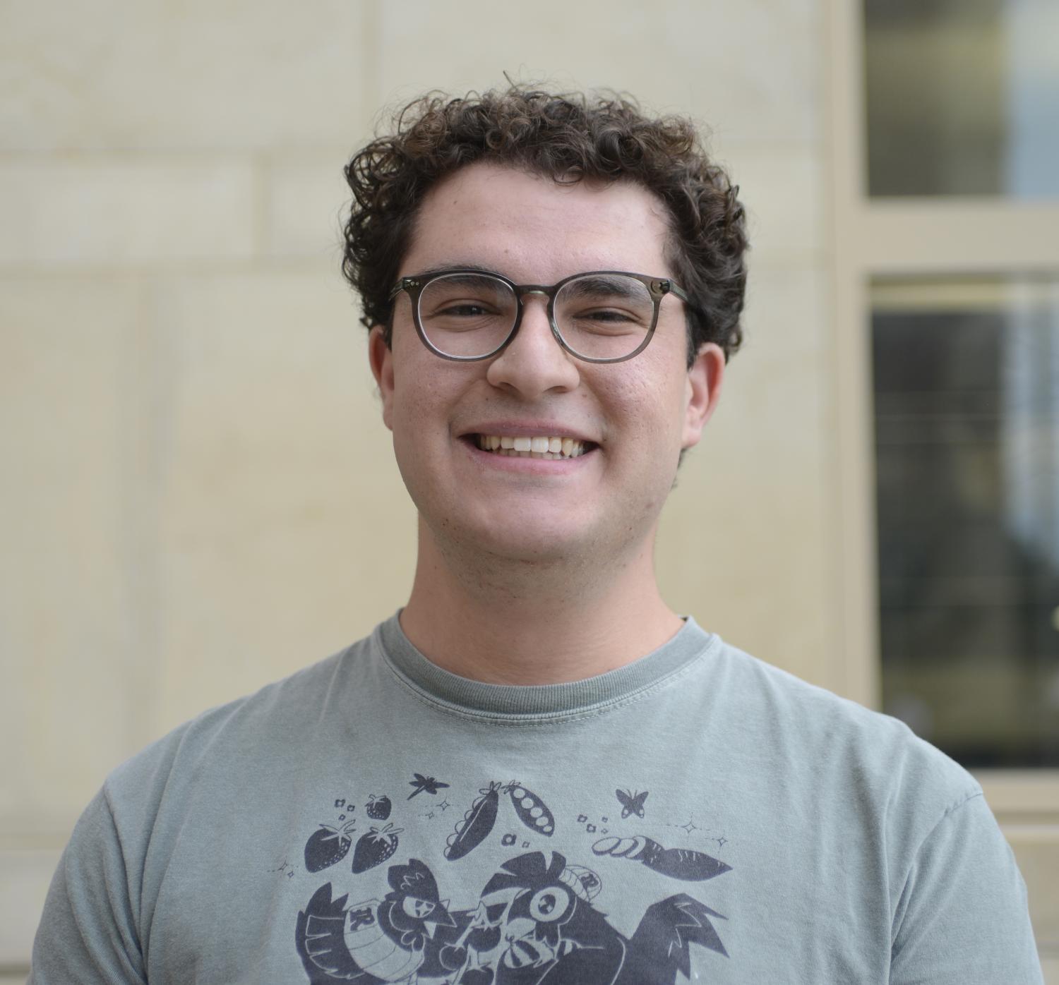 Jonathan Makhoul in a T-shirt and wearing glasses, with a blurred wall behind him.