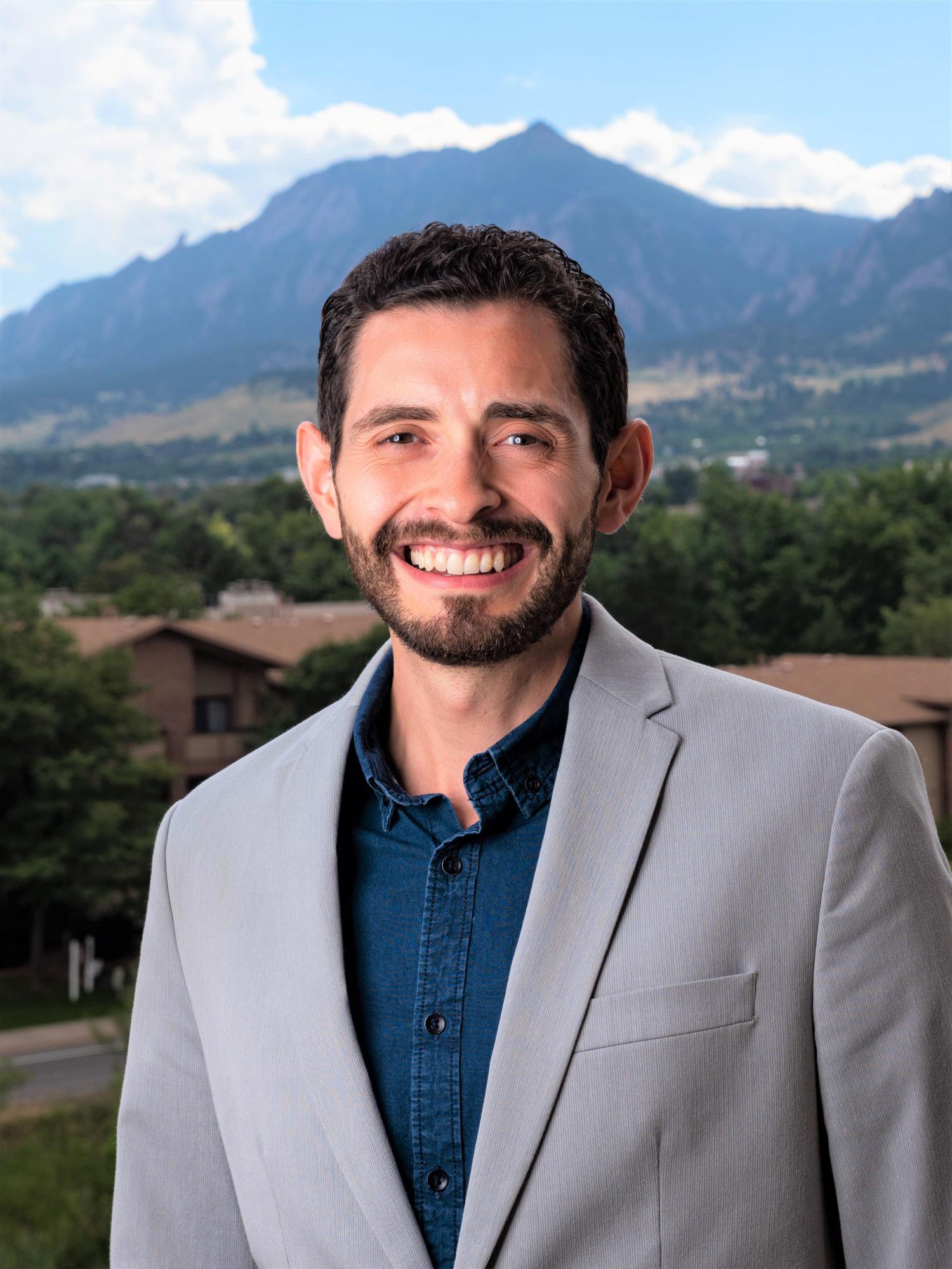 Brian Aguado in grey suit with Flatirons background