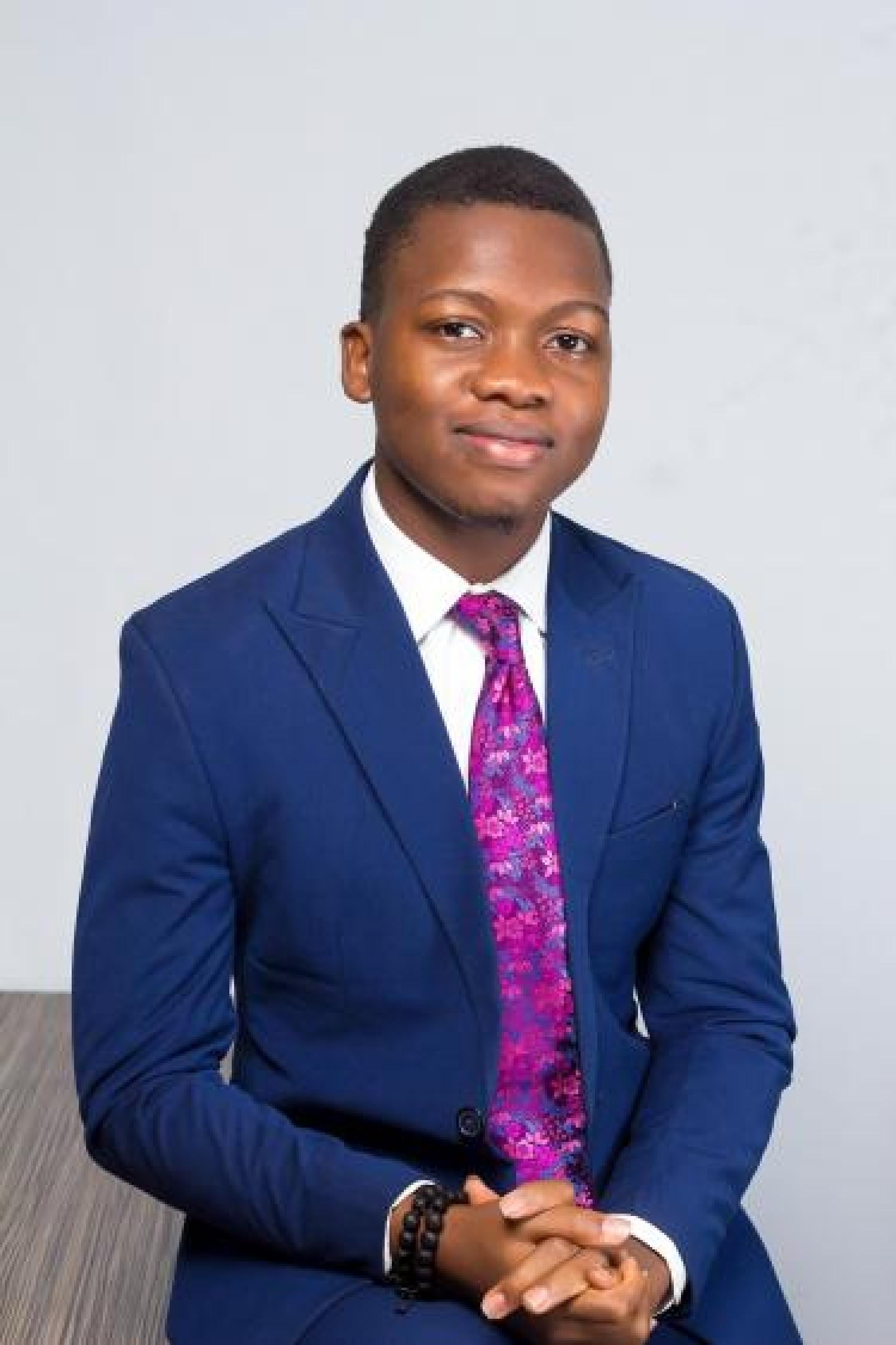 Dami Akinneye in blue suit and purple tie