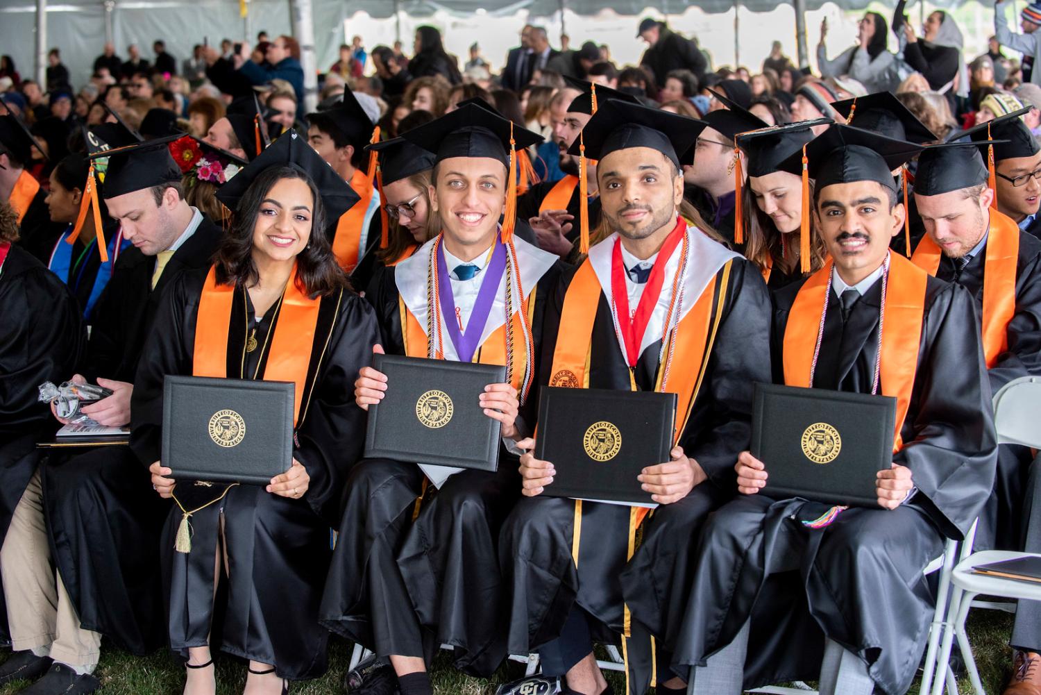 Graduates display their diploma cases