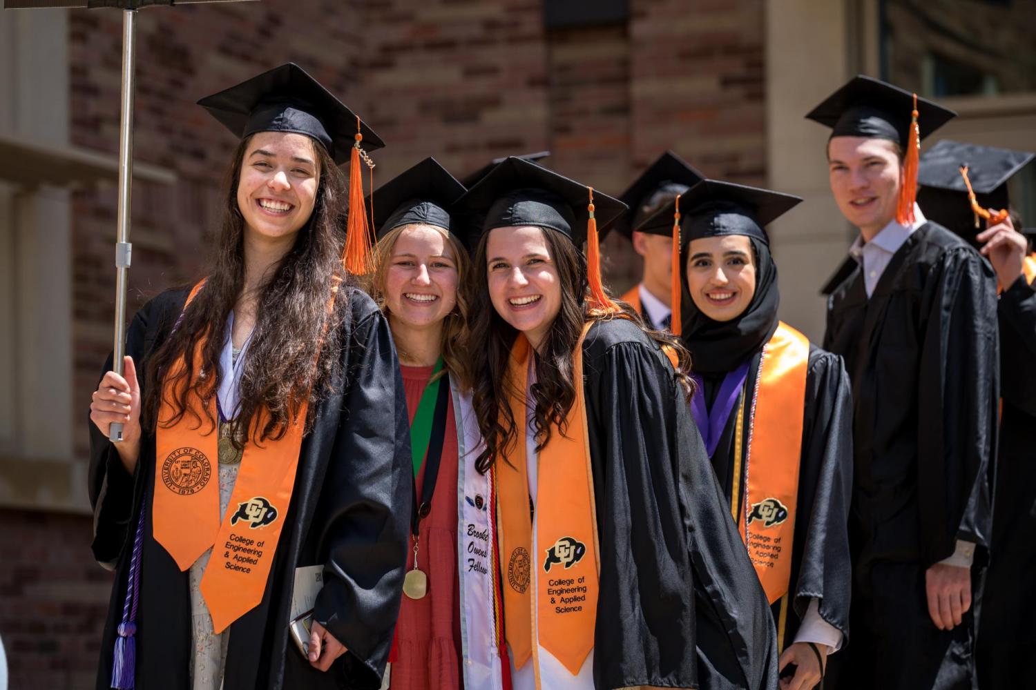 Graduating students in regalia pose before processional