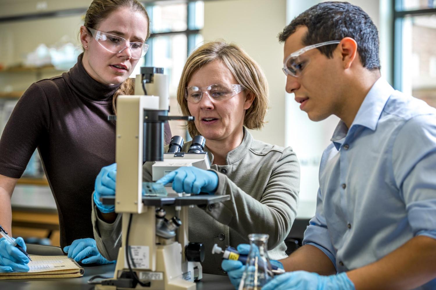 Students working with professor in lab