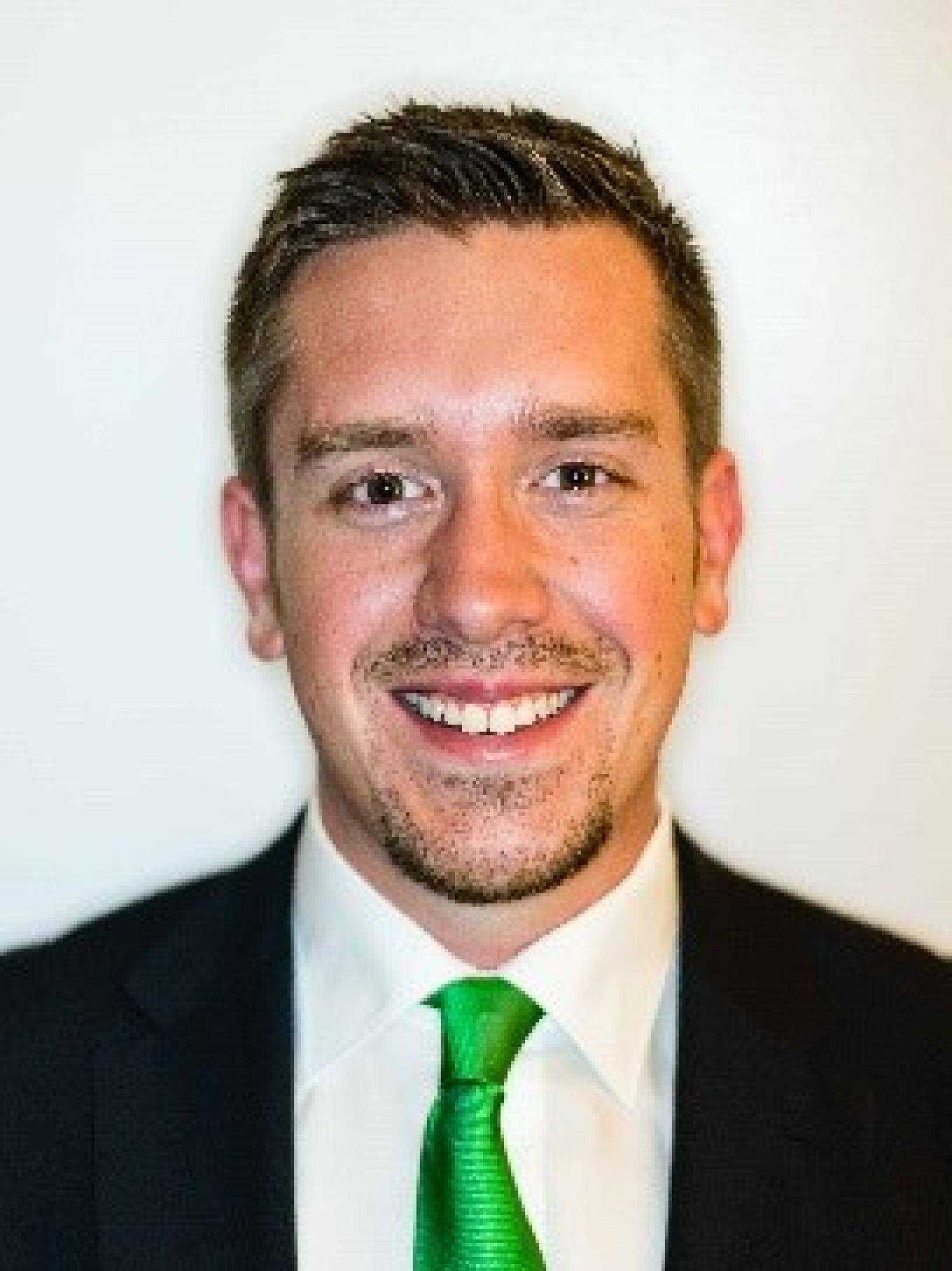 Peter in black suit with green tie