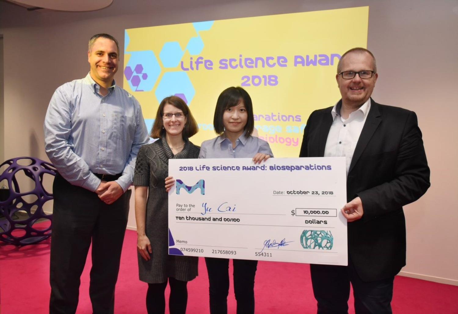 Graduate student Yu Cai receives a big award check for $10,000.