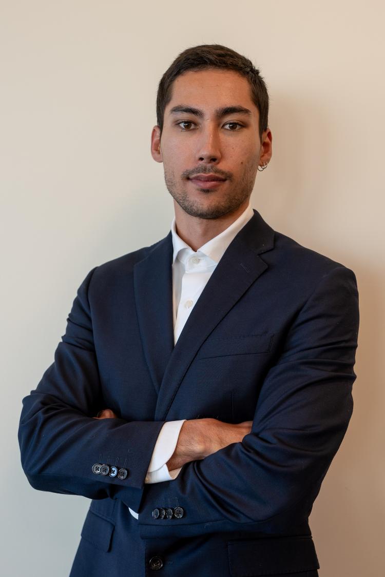 Luis Kitsu Iglesias in a suit jacket standing with his arms folded.