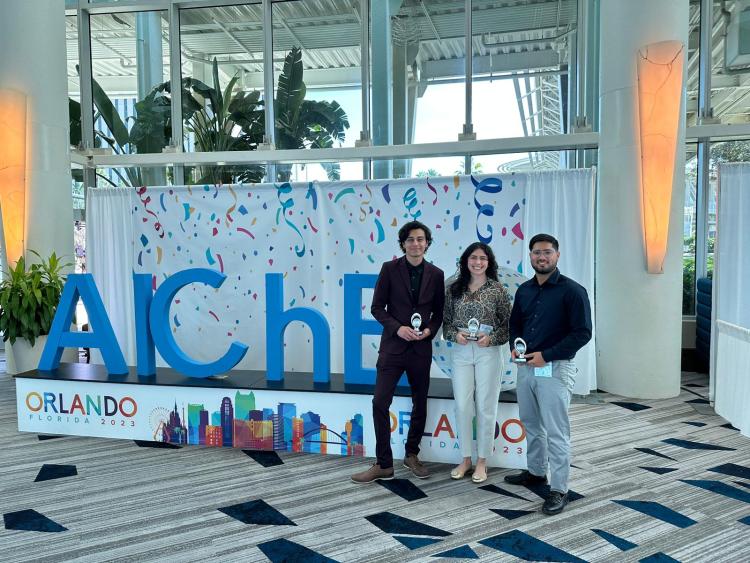 Barrientos and two other students hold an award at the AIChE conference