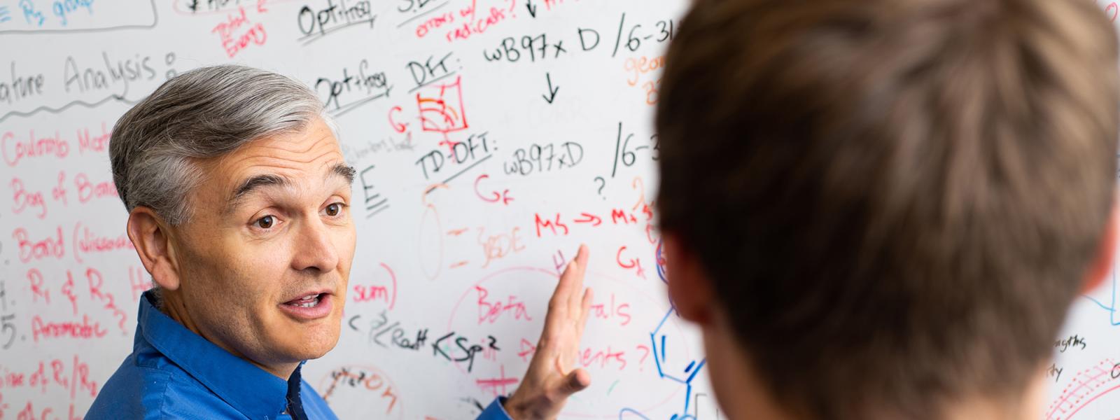 Professor Musgrave discusses board notes with student