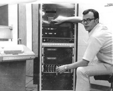 Grad Student Dave Clough with computer system he built for his PhD research (1970s).