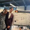 Barrientos and another unidentified student in front of a poster.