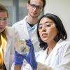 Students look at a sample in a lab.