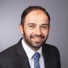 Ehsan Keyvani in black suit with white shirt and blue tie