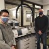 Justin Tran and Kent Warren pose in front of lab equipment