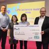 Graduate student Yu Cai receives a big check for $10,000.