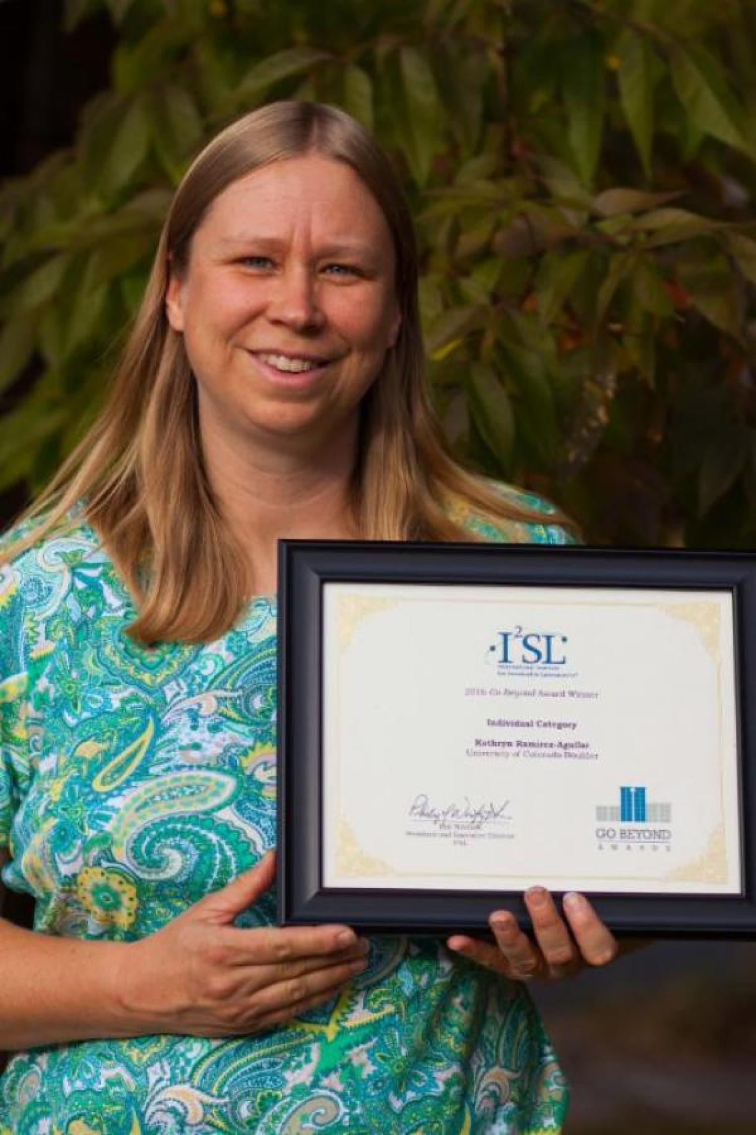 Kathy Ramirez-Aguilar holding I2SL Award