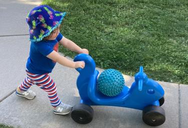 toddler pushing a toy