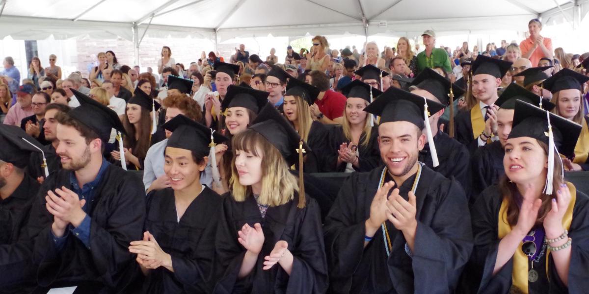 Large group of graduating students clapping