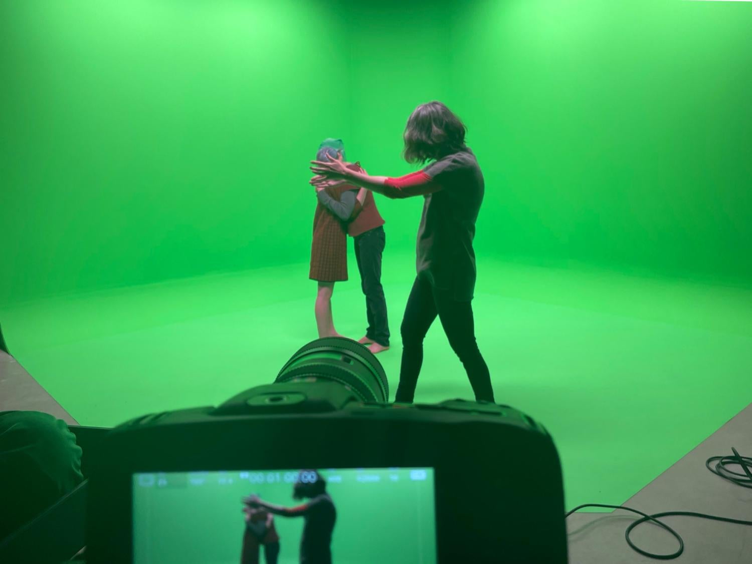 Kelly Sears in the Green Studio directing dancers movement in the green screen space in front of the camera.