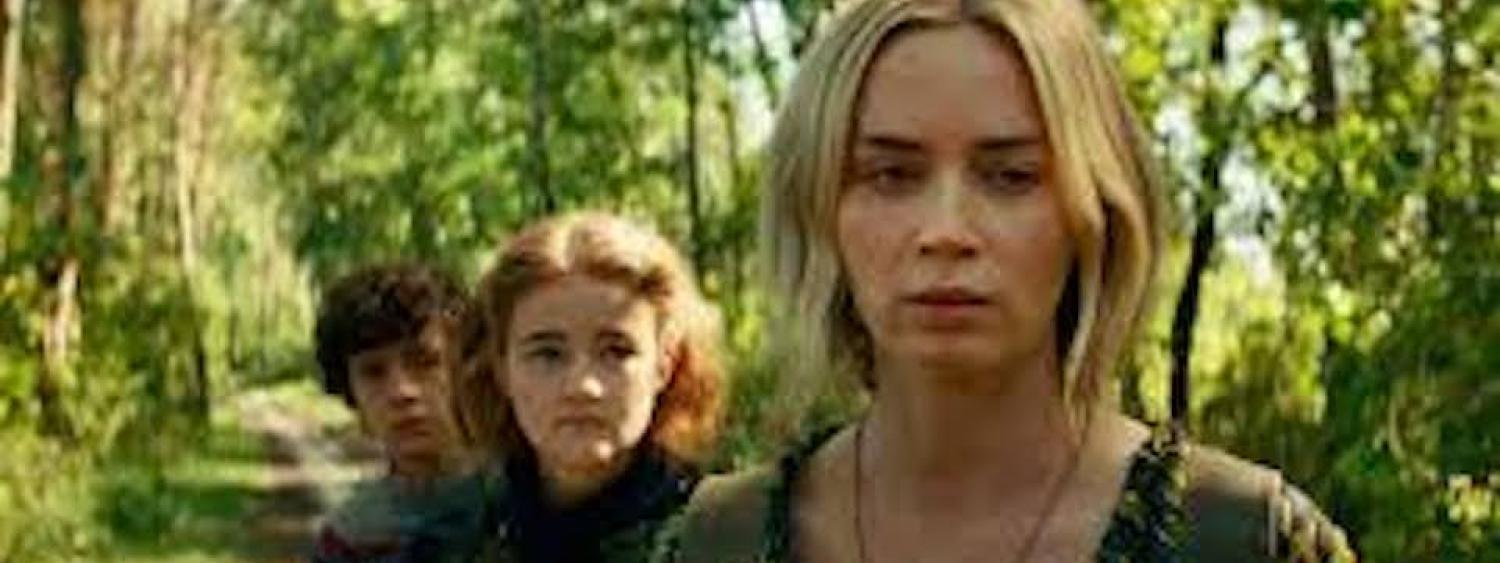 Actors Emily Blunt, Millicent Simmonds, and Noah Jupe in A Quiet Place Part II. The Actors walk through a forest at day time 
