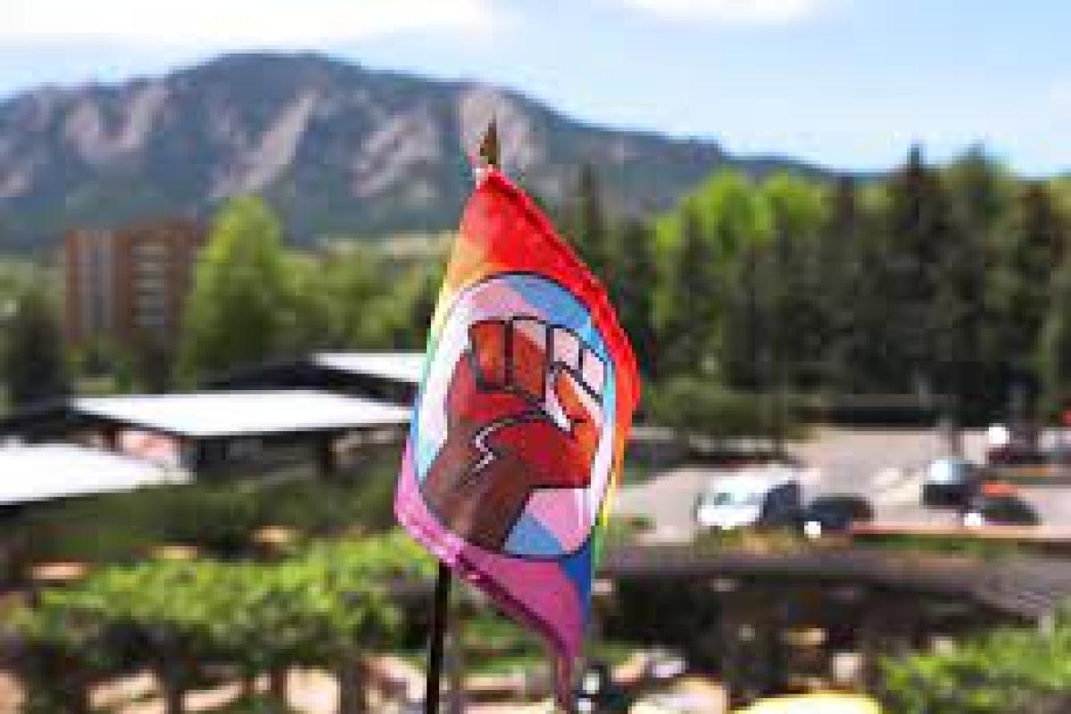 The QTPOC Pride Flag being waved over the Flatirons.