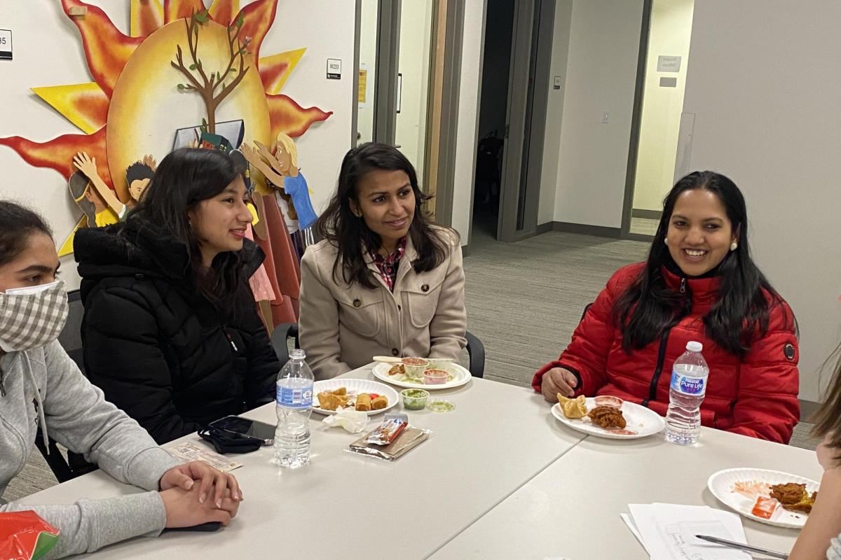 students talk and smile together at an AAPI community gathering