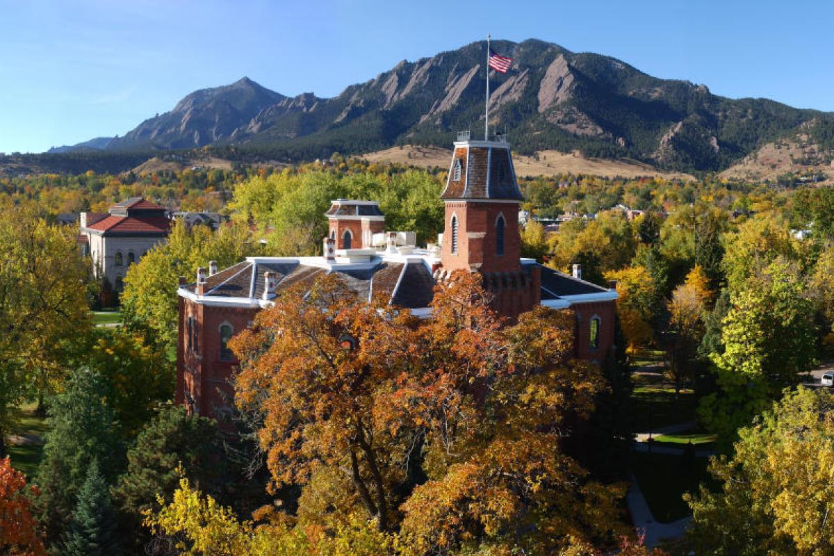 a view of old main surrounded in fall foliage