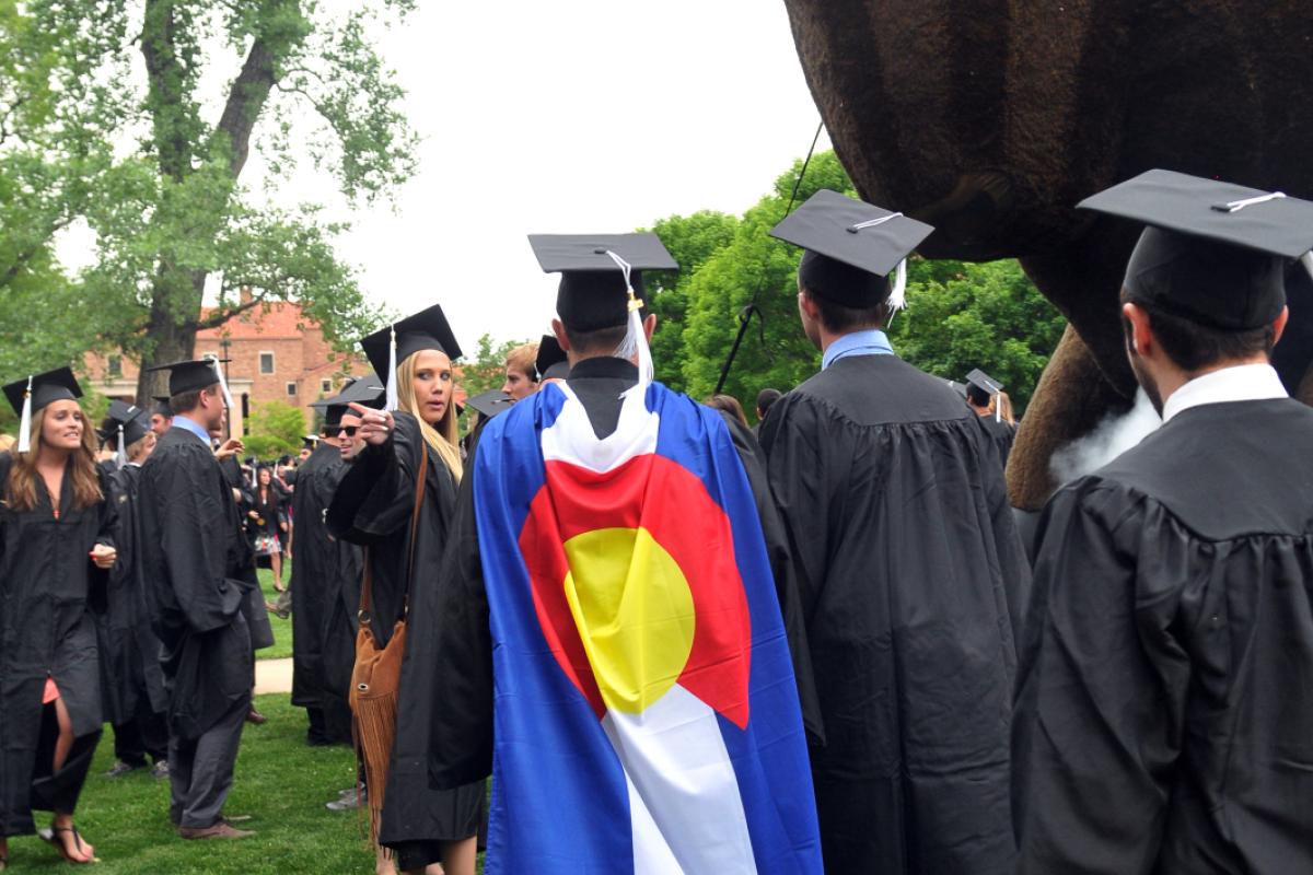 Graduate wearing Colorado flag cape