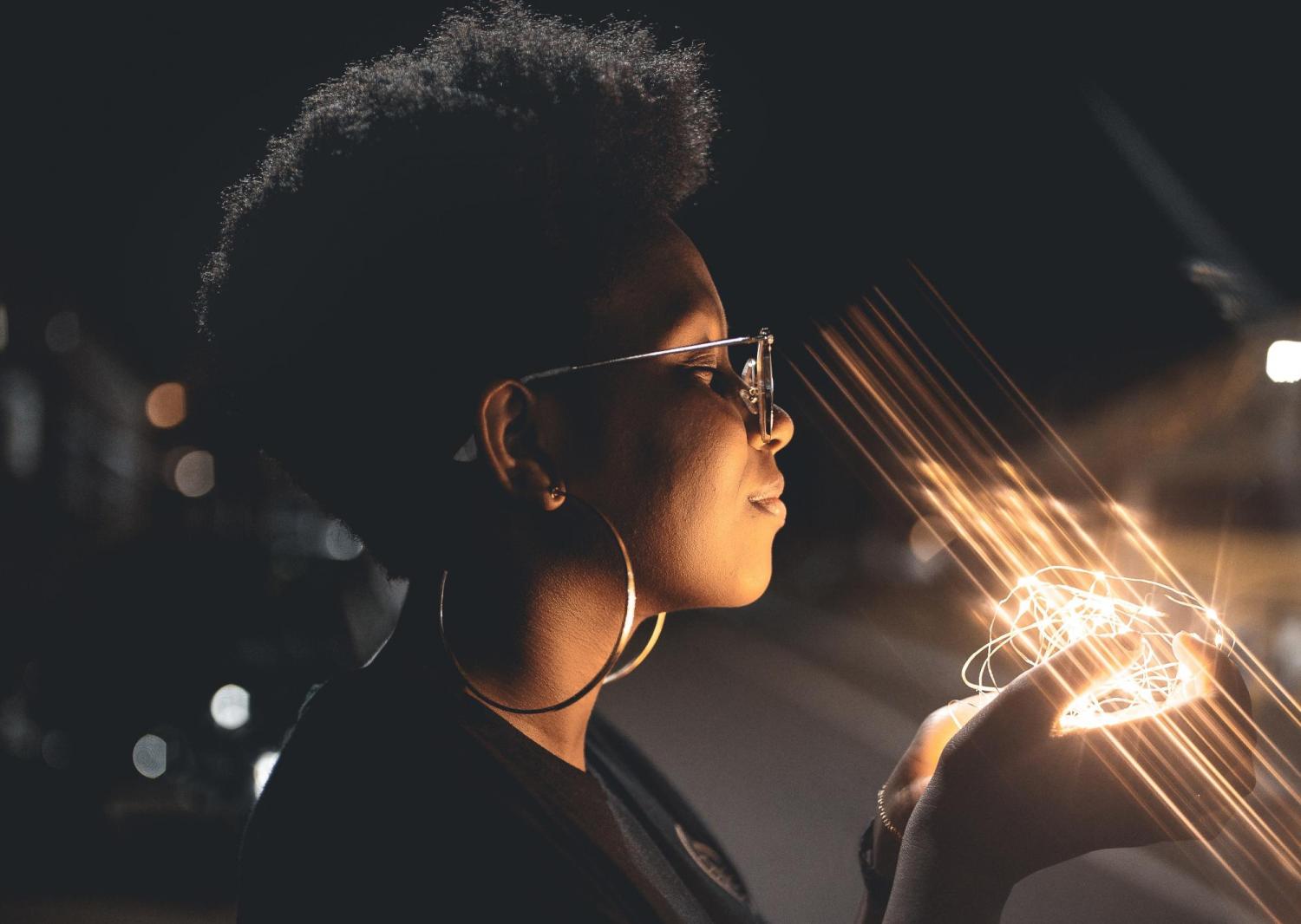 Black women holding light in hands