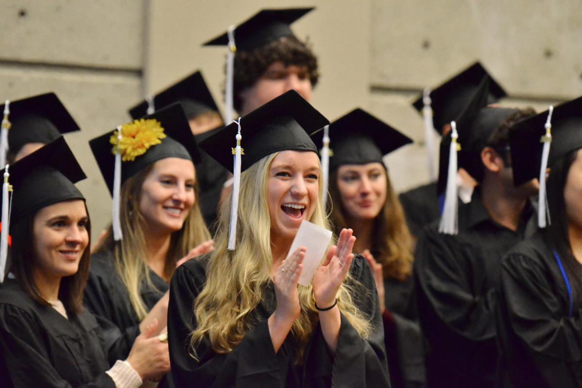 students in graduation clothes cheering