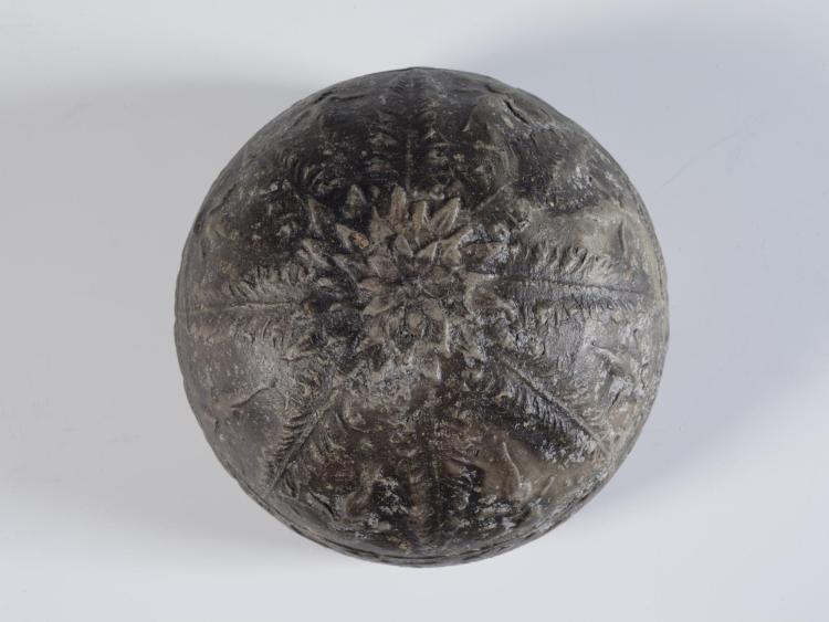 Photograph of underside of relief mould-made bowl against neutral gray background.