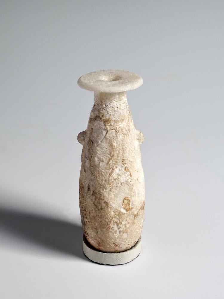 Photograph of white stone alabastron, from the side against a neutral gray background.