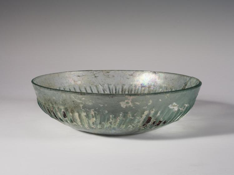 Photo of a clear glass bowl, from the side against a neutral gray background.