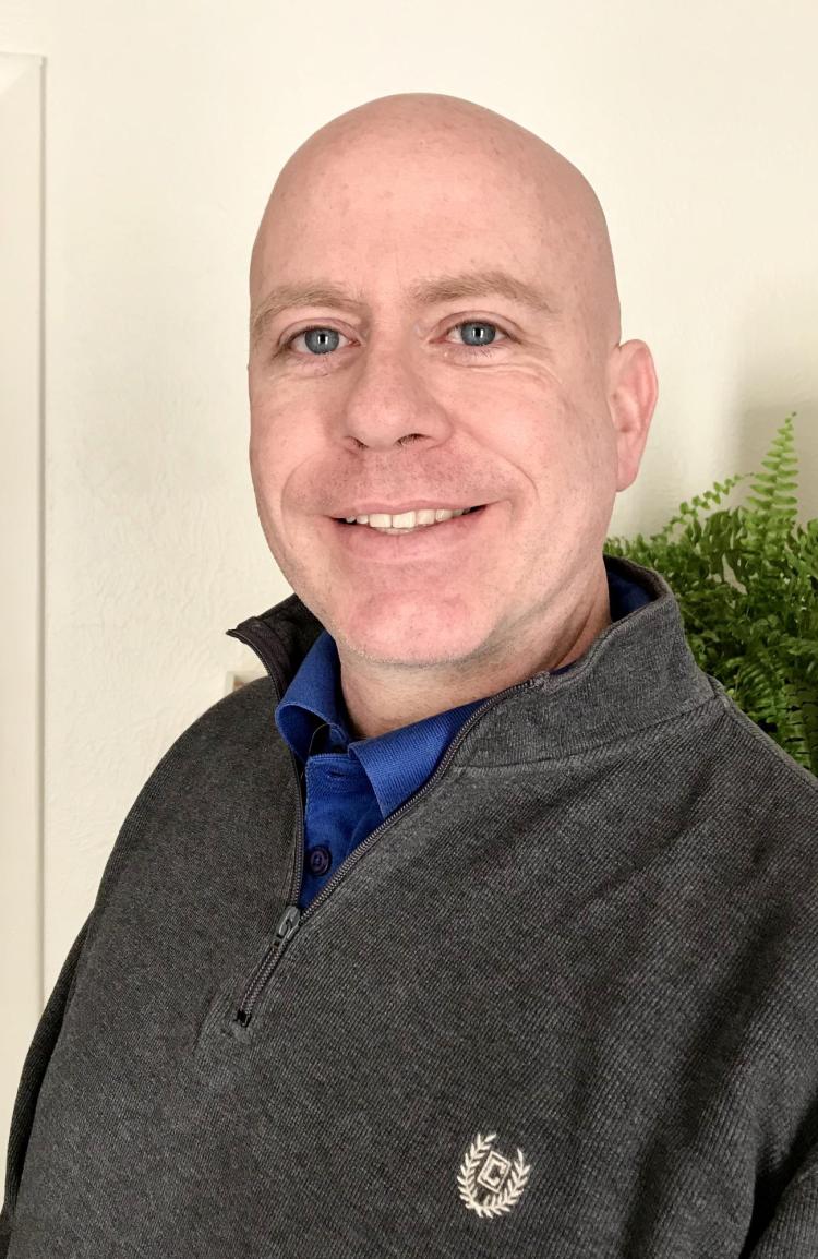 Head shot of Steve Slater with plant in background