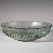 Photo of a clear glass bowl, from the side against a neutral gray background.
