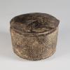 Photograph of cylindrical pyxis with lid in place, from the side against a neutral gray background.