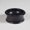 Photograph of all-black salt cellar, from raised but not high angle against a neutral gray background.