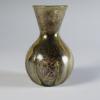 Photograph of glass vase, with flat bottom, rounded body, and neck with straight sides that flare outward to mouth, from the side against a neutral gray background.