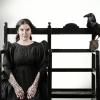 woman sitting on chair with raven