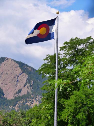 Photo of Colorado state flag with trees in background