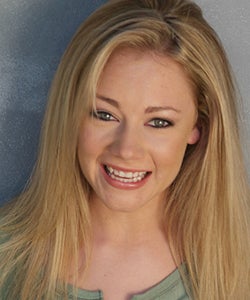 Headshot of Casey smiling against a neutral-colored background.