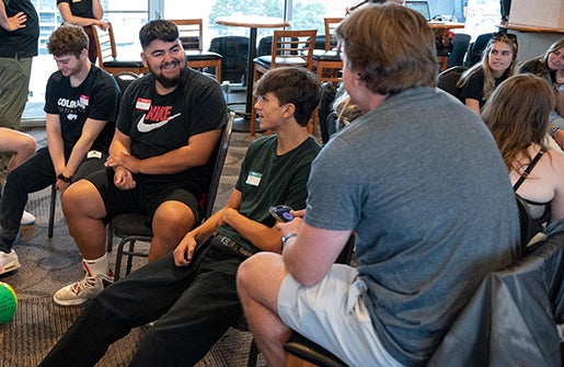 New students seated in a circle during orientation get to know one another.