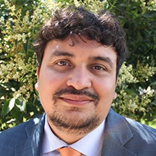 Headshot of Ever in a blue suit and orange tie.