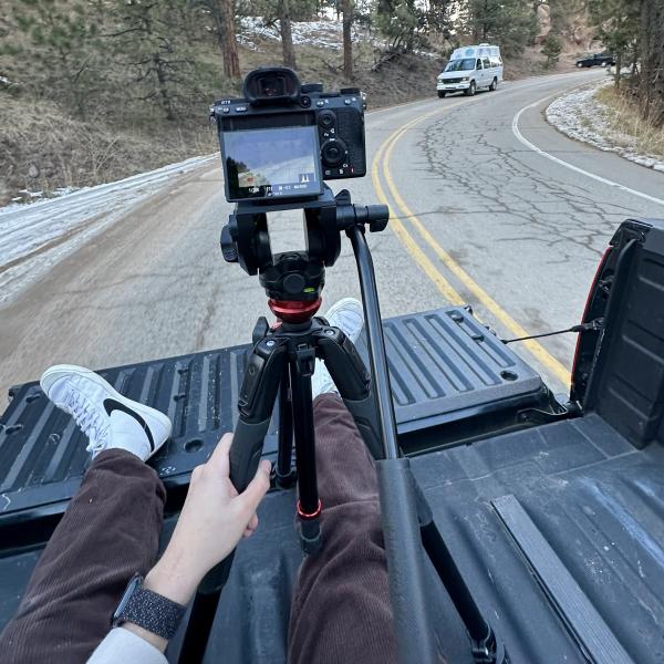 A video camera records a van driving along a winding mountain road.
