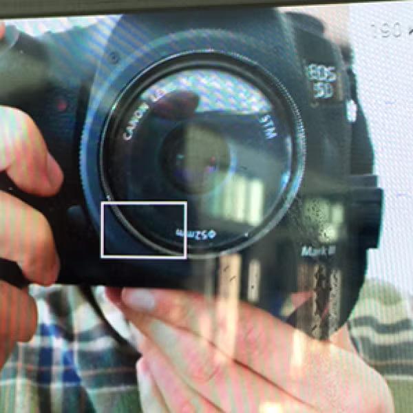 A photo of a screen with a photo of someone taking a picture.