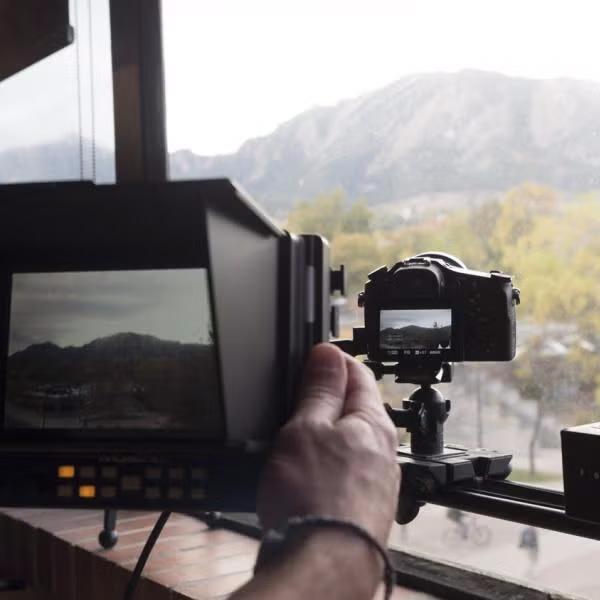 A camera operator monitors his camera's output through a monitor.
