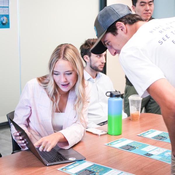 Two students gather around a computer