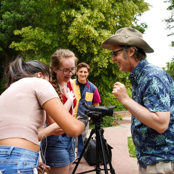 Instructor Paul Daugherty helps Pathways students Juanita Hurtado and Presley Nemecek with their camera at Varsity Lake.